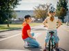 Eine Velokurs-Instruktorin gibt einem Schulkind Tipps fürs Velofahren auf der Strasse